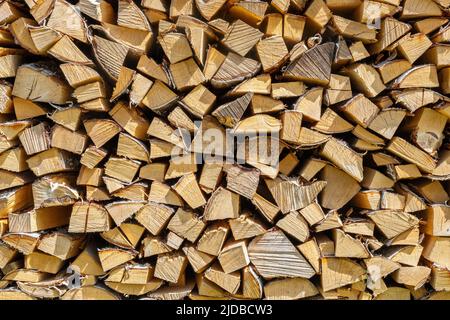 Wand aus gehacktem und gestapeltem Brennholz Stockfoto