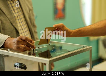 Der Mann gab seine Stimme ab, als er in einem Wahllokal in Frankreich für die Wahlen abstimmt Stockfoto