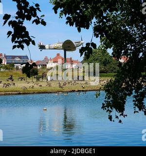 Replik Spitfire Flugzeug umgeben von kanadagänsen am Fairhaven See, Lytham, Lancashire, Großbritannien Stockfoto