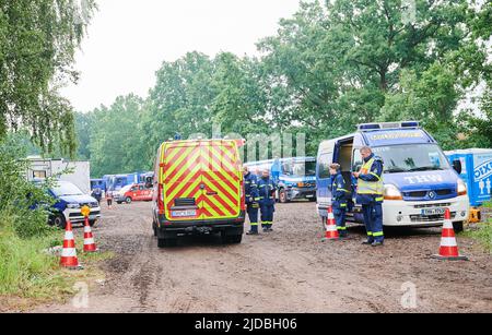 20. Juni 2022, Brandenburg, Treuenbrietzen: Auf einem Spielplatz und Fußballplatz bei Treuenbrietzen, wo die Einsatzkräfte untergebracht sind, wurde ein Einsatzgebiet für Feuerwehr, THW und Polizei eingerichtet. Heftige Regenfälle haben am frühen Montagmorgen im Kampf gegen zwei große Waldbrände in Brandenburg Abhilfe gebracht. Zunächst brannten bei Treuenbrietzen – 80 Kilometer südwestlich von Berlin – noch 135 Hektar Wald in der Nacht, so Beamte am Tatort. Kurz nach 7:00 Uhr wurde der Regen jedoch schwerer. Das Regenradar zeigte auch für die nächsten paar Niederschläge und Gewitter an Stockfoto