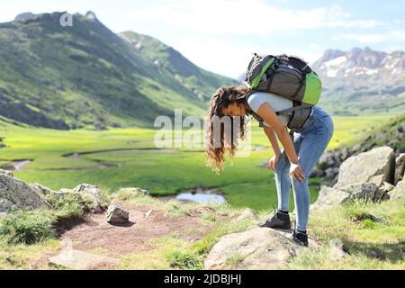 Profil eines erschöpften Wanderers, der sich nach dem Besteigen eines Berges ausruhte Stockfoto