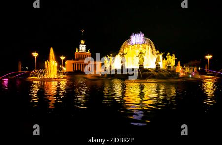 Fontaine „Druzhba Narodov“. Der Brunnen der Völkerfreundschaft ist eines der Symbole von VDNH und Moskau. Nachts beleuchtet. Stockfoto