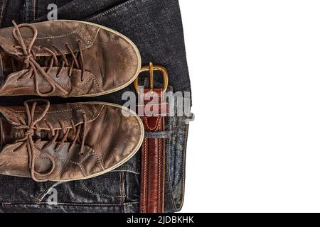 Stilvoll verquälte braune Lederschuhe und schwarze Jeans mit Ledergürtel isoliert auf weißem Hintergrund. Lifestyle und Mode Stockfoto