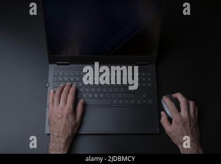 Tastatur für Laptop-Computer mit Benutzer- oder Gamer-Händen auf schwarzem, elegantem Hintergrund. Technologie, Business, Internet-Konzept. Hochwertige Fotos Stockfoto