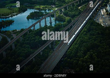 (220620) -- WUHAN, 20. Juni 2022 (Xinhua) -- Luftfoto zeigt einen Hochgeschwindigkeitszug, der auf dem Abschnitt Peking-Wuhan der Hochgeschwindigkeitsbahn Peking-Guangzhou in Wuhan, der zentralchinesischen Provinz Hubei, am 20. Juni 2022 fährt. Eine Hochgeschwindigkeitsstrecke, die Peking mit Wuhan, der Hauptstadt der zentralchinesischen Provinz Hubei, verbindet, nimmt am Montag den Normalbetrieb mit einer Geschwindigkeit von 350 km/h auf, sagte die China State Railway Group Co., Ltd. Mit einer von 310 km/h auf 350 km/h angehobenen Zuggeschwindigkeit. Die Gesamttransportkapazität des Abschnitts soll um 7 Prozent steigen und die kürzeste Strecke zwischen Peking und Stockfoto