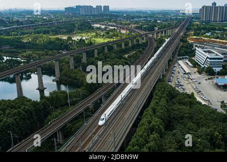 (220620) -- WUHAN, 20. Juni 2022 (Xinhua) -- Luftfoto zeigt einen Hochgeschwindigkeitszug, der auf dem Abschnitt Peking-Wuhan der Hochgeschwindigkeitsbahn Peking-Guangzhou in Wuhan, der zentralchinesischen Provinz Hubei, am 20. Juni 2022 fährt. Eine Hochgeschwindigkeitsstrecke, die Peking mit Wuhan, der Hauptstadt der zentralchinesischen Provinz Hubei, verbindet, nimmt am Montag den Normalbetrieb mit einer Geschwindigkeit von 350 km/h auf, sagte die China State Railway Group Co., Ltd. Mit einer von 310 km/h auf 350 km/h angehobenen Zuggeschwindigkeit. Die Gesamttransportkapazität des Abschnitts soll um 7 Prozent steigen und die kürzeste Strecke zwischen Peking und Stockfoto