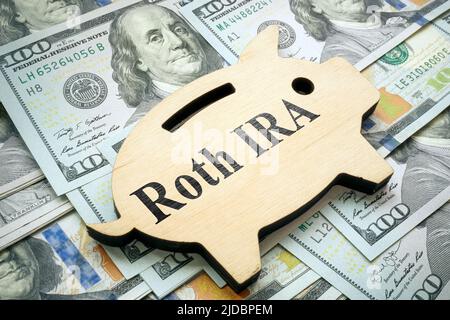 Sparschwein mit Schild Roth IRA auf Geld. Stockfoto