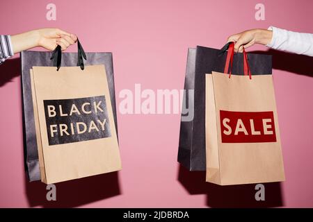 Nahaufnahme von nicht erkennbaren Frauen, die Einkäufe in Papiertüten halten, die beim Black friday Sale gekauft wurden Stockfoto