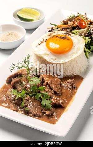 Traditionelles kambodschanisches Lok Lak Rührbeef mit Reisgericht auf weißem Hintergrund Stockfoto