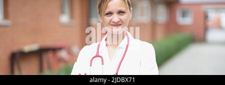 Eine Ärztin steht auf der Straße in der Nähe der Klinik Stockfoto