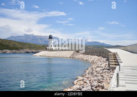 Pfad zum Leuchtturm vor der Kulisse der Berge und des blauen Himmels. Stockfoto