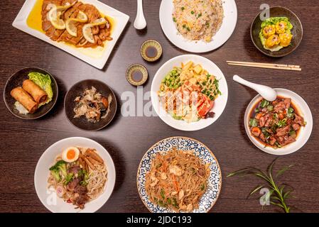 Set von asiatischen Gerichten mit Frühlingsrollen, Zitronenhuhn, drei Delight Reis, würzigen Rind- und Schweinefleisch Ramen und Nudeln Stockfoto