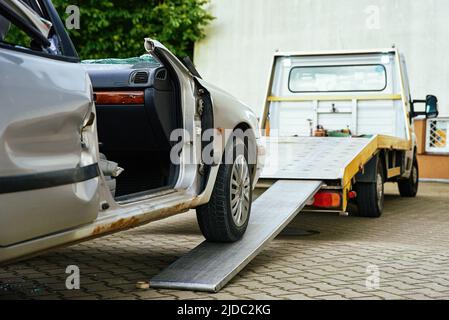 Zerstörte Autoverladung auf Abschleppwagen nach Unfall, Konzept des gefährlichen Fahrens nach Alkoholkonsum, Pannenhilfe Konzept Stockfoto