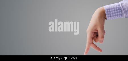 Mit den Fingern auf grauem Hintergrund und leerem Kopierbereich Stockfoto