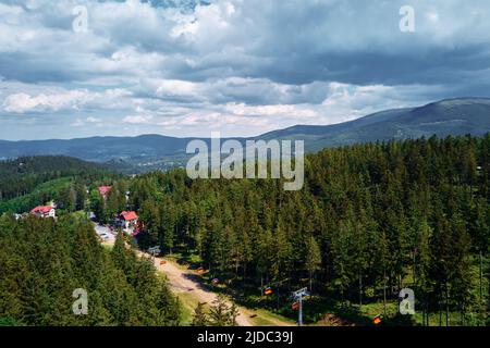 Luftaufnahme der schönen Berge, bedeckt mit Wald und offene Seilbahn Straße. Karpacz Resort in Polen mit Lift Road. Erholung im Freien für die ganze Familie in den Bergen Stockfoto