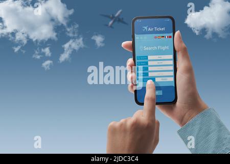 Benutzer, der ein Smartphone hält und günstige Flüge online bucht, Himmel im Hintergrund, POV-Aufnahme Stockfoto