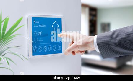 Mann überprüft ein intelligentes Home-Touchscreen-Bedienfeld, Home-Automation-Konzept Stockfoto