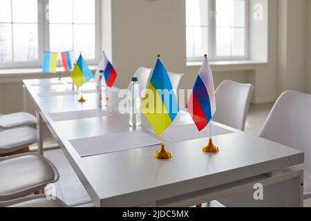 Tisch mit Flaggen der Ukraine und Russlands bei Verhandlungen zur Wiederherstellung des Friedens zwischen den Ländern Stockfoto