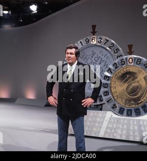 Drei mal neun, ZDF Quizshow, Deutschland, 1971, im Bild: Showmaster Wim Thoelke vor den Glücksrädern. Drei mal neun, TV-Quizshow, Deutschland, 1971, auf dem Foto: Moderator Wim Thoelke vor den Rädern des Glücks. Stockfoto