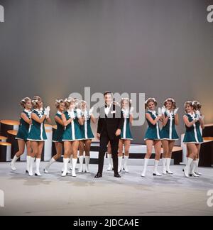 Drei mal neun, ZDF Quizshow, Deutschland, 1971, im Bild: Showgast Peter Alexander mit Tänzerinnen des ZDF Fernsehballetts. Drei mal neun, TV-Quizshow, Deutschland, 1971, auf dem Foto: Schaugast Peter Alexander mit Tänzern des TV-Balletts. Stockfoto