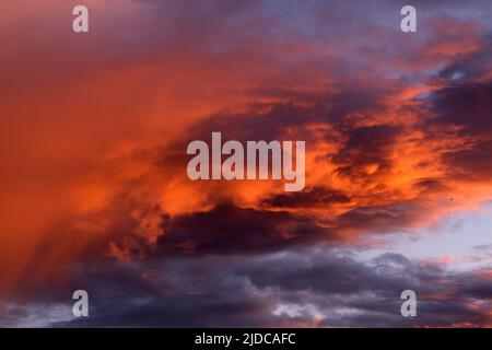 Die Wolken werden leuchtend orange, wenn die letzten Sonnenstrahlen auf sie treffen, während sich eine vorbeiziehende Kaltfront über das Murray Darling Basin bewegt. Stockfoto