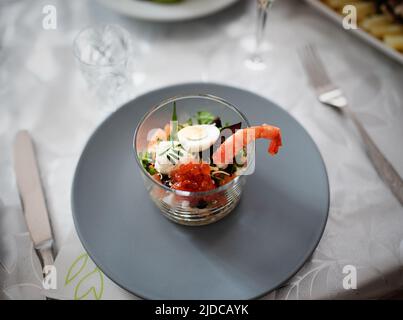 Gesunder Salat in einem Glas mit Wachtelei und Garnelen Stockfoto