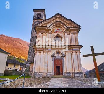 Die schöne mittelalterliche Fassade der Kirche Santa Maria degli Angeli mit Fresko, Wandsäulen, Stuckdekoren und steinernen Uhrturm, Lavertezzo, Valle Verza Stockfoto