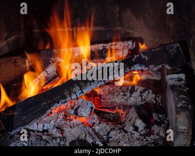 Flamme der schwelenden und brennenden Kohle im Kamin Stockfoto