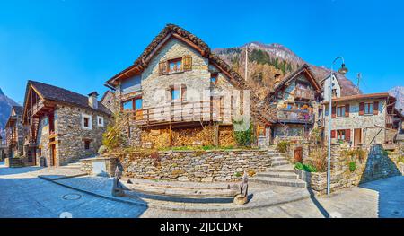 Panorama der alten Dorfstraße mit traditionellen alpinen Steinhäusern und Bergen im Hintergrund, Sonogno, Valle Verzasca, Schweiz Stockfoto