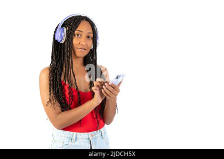 Junge schwarze Frau hört Musik mit ihrem Telefon auf weißem Hintergrund Stockfoto