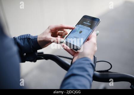 Kurier mit dem Fahrrad und Blick auf das Handy asnd mit Lieferung App, nachhaltige Transportkonzept Stockfoto