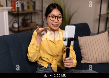 Asiatische Blogger Dame Macht Video Auf Handy Sitzen Zu Hause Stockfoto