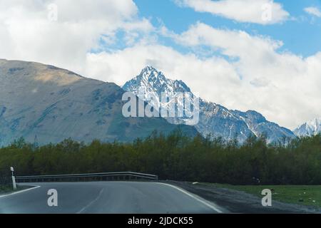 Straße in Sno und Kaukasus-Gebirge in der Ferne, Georgien. Hochwertige Fotos Stockfoto