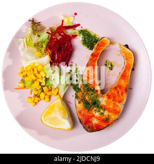 Gebackenes Lachssteak mit grüner Sauce, Zitrone und Gemüse Stockfoto