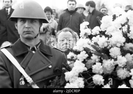 Bundeskanzler Willy BRANDT schaut bei der Kranzniederlegung im ehemaligen KZ Buchenwald anlässlich eines Treffens mit dem DDR-Ministerpräsidenten Willi Stoph am 19. März 1970 in Erfurt zwischen einem NVA-Soldaten und einem Blumenstrauß durch; schwarz-weiß-Schuss; Stockfoto