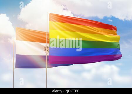 Sonniger blauer Himmel und Flaggen von lgbt und paraguay Stockfoto