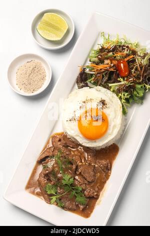 Traditionelles kambodschanisches Lok Lak Rührbeef mit Reisgericht auf weißem Hintergrund Stockfoto