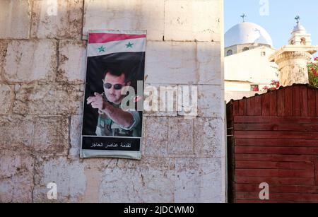 Ein Plakat des syrischen Präsidenten Baschar Al Assad am 19. Juni 2022 am Bab Sharki Gate in Damaskus, Syrien. Während die Otschwellen der Hauptstadt stark an den Auseinandersetzungen des letzten syrischen Bürgerkrieges beteiligt waren, ist die Altstadt von Damaskus nicht betroffen. (Foto von Elisa Gestri /Sipa USA) Stockfoto