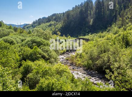 Die abgelegene Hatsios-Brücke, die sich anmutig über den Vikakis-Fluss spannt, bevor sie in die Vikakis-Schlucht - Zagori-Region des Pindus-Gebirges Griechenland einmündet Stockfoto