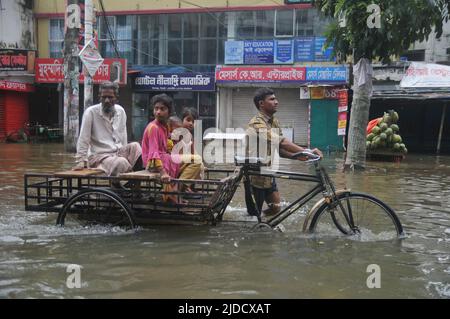 Sylhet, Bangladesch. 20.. Juni 2022. Menschen, die in Rikschas bei Überschwemmungen unterwegs sind. Die schlimmsten Überschwemmungen seit fast 20 Jahren haben Teile Bangladeschs verwüstet, Dutzende von Menschen getötet und Millionen gestrandet. Stockfoto