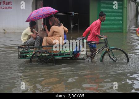 Sylhet, Bangladesch. 20.. Juni 2022. Menschen, die während der Flutkatastrophe in einem Wagen unterwegs sind. Die schlimmsten Überschwemmungen seit fast 20 Jahren haben Teile Bangladeschs verwüstet, Dutzende von Menschen getötet und Millionen gestrandet. Stockfoto