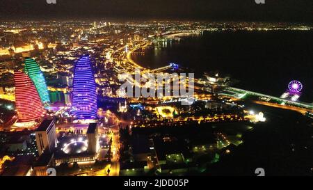 Nachtansicht auf die Flammentürme der Stadt Baku mit bunten Lichtern, Skyline-Drohne aus der Luft, Aserbaidschan, Südkaukasus Stockfoto