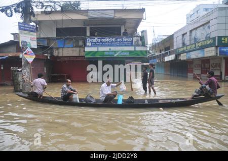 Sylhet, Bangladesch. 20.. Juni 2022. Menschen, die während Überschwemmungen in einem Floß unterwegs sind. Die schlimmsten Überschwemmungen seit fast 20 Jahren haben Teile Bangladeschs verwüstet, Dutzende von Menschen getötet und Millionen gestrandet. Stockfoto