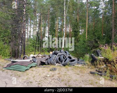 Illegal in der Natur entsorgte Abfälle und alte gebrauchte Autoreifen Stockfoto