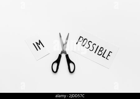 Es ist möglich Konzept. Mit einer Schere wird das Wort unmöglich möglich Stockfoto