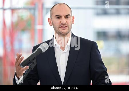 20. Juni 2022, Baden-Württemberg, Tübingen: Danyal Bayaz (Bündnis 90/die Grünen), Finanzminister Baden-Württembergs, spricht bei der feierlichen Grundsteinlegung für den Innovationscampus „Cyber Valley“ in Tübingen. Das "Cyber Valley" ist Europas größte Forschungskooperation im Bereich der künstlichen Intelligenz mit Partnern aus Politik, Wissenschaft, Wirtschaft und Gesellschaft. Das Gesamtkonzept für den Standort Tübingen umfasst neben dem neuen Cyber Valley I Gebäude, das 2016 genehmigt wurde, zwei weitere Neubauten. Foto: Bernd Weißbrod/dpa Stockfoto