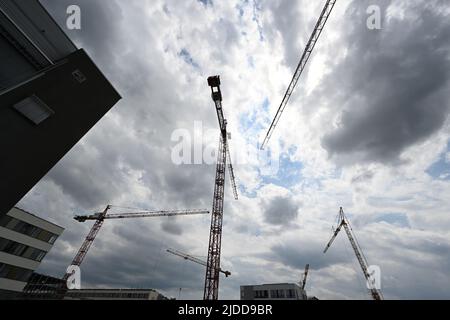 20. Juni 2022, Baden-Württemberg, Tübingen: Krane stehen während der feierlichen Grundsteinlegung auf der Baustelle für den ersten Rohbau des Innovationscampus „Cyber Valley“ in Tübingen. Cyber Valley' ist die größte Forschungskooperation Europas im Bereich der künstlichen Intelligenz mit Partnern aus Politik, Wissenschaft, Wirtschaft und Gesellschaft. Das Gesamtkonzept für den Standort Tübingen umfasst neben dem neuen Cyber Valley I Gebäude, das 2016 genehmigt wurde, zwei weitere Neubauten. Foto: Bernd Weißbrod/dpa Stockfoto