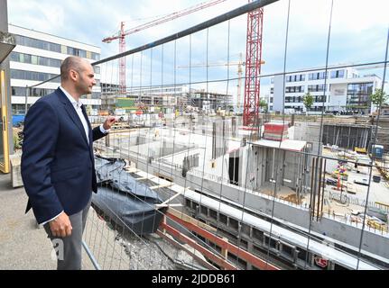 20. Juni 2022, Baden-Württemberg, Tübingen: Der baden-württembergische Finanzminister Danyal Bayaz (Bündnis 90/die Grünen) blickt bei der feierlichen Grundsteinlegung für den Innovationscampus „Cyber Valley“ in Tübingen auf den ersten Teil der Schale. Das "Cyber Valley" ist Europas größte Forschungskooperation im Bereich der künstlichen Intelligenz mit Partnern aus Politik, Wissenschaft, Wirtschaft und Gesellschaft. Das Gesamtkonzept für den Standort Tübingen umfasst neben dem neuen Cyber Valley I Gebäude, das 2016 genehmigt wurde, zwei weitere Neubauten. Foto: Bernd Weißbro Stockfoto