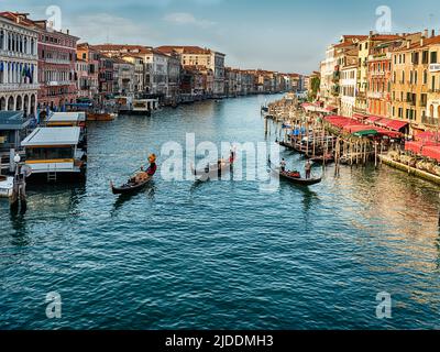 Drei Gondeln fahren am frühen Morgen auf dem Canal Grande in Venedig von der Rialtobrücke aus gesehen. Stockfoto