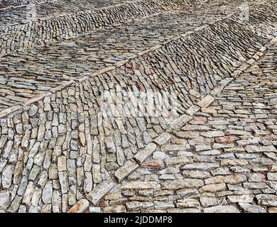 Die Steine des Hofes sind in einem interessanten Muster auf dem Schloss in Serralungo angeordnet. Stockfoto